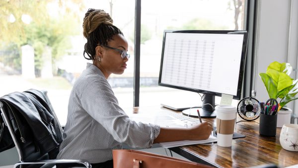 Busy businesswoman concentrates while working at her desk A mid adult African American businesswoman concentrates while working in her office.