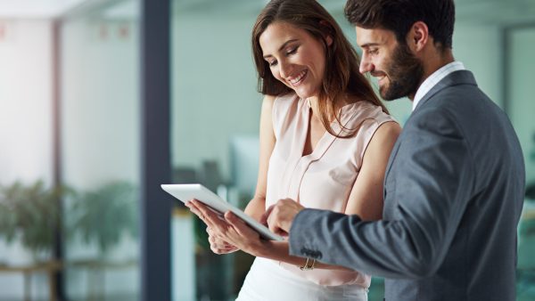 Positivity inspires productivity Shot of a young businessman and businesswoman using a digital tablet together in an office